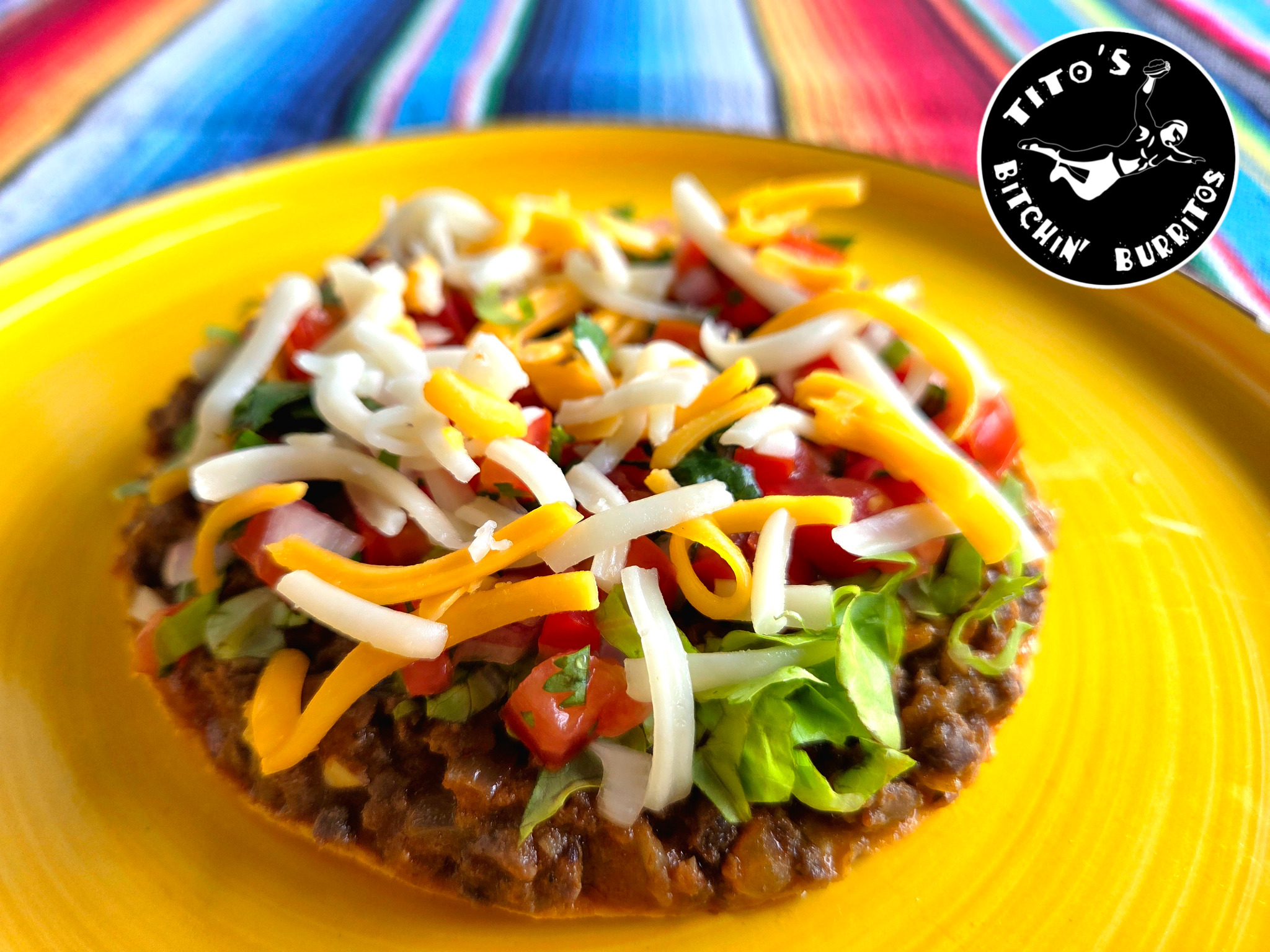 Refried beans topped with cheese and pico de gallo at Tito's Bitchin' Burritos