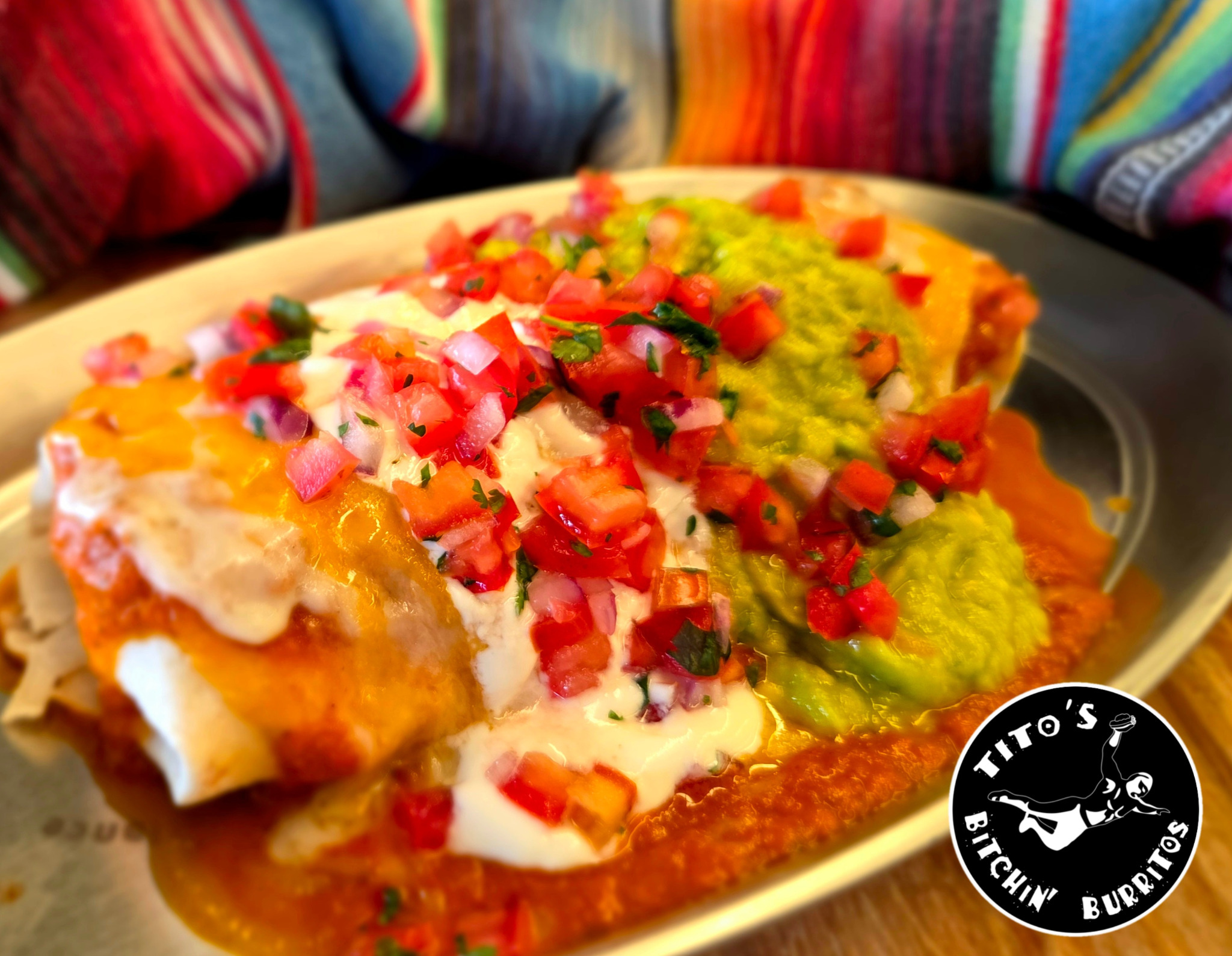 Enchilada-style dish with pico de gallo, sour cream, and guacamole at Tito's Bitchin' Burritos